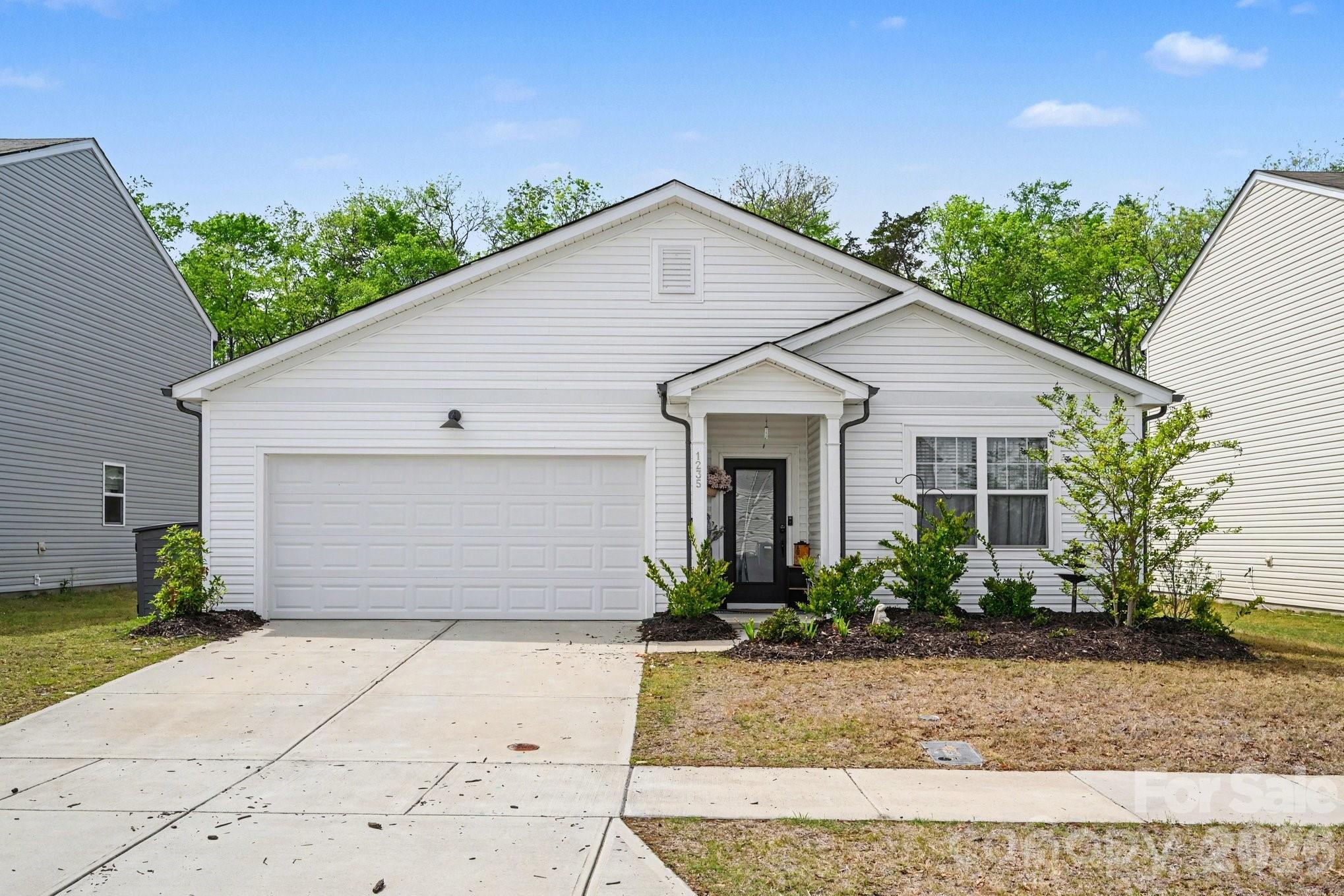 1235 Nesters Store Place Southwest Concord, NC 28027 - Photo 2 of 21 a view of a white house with a yard and potted plants