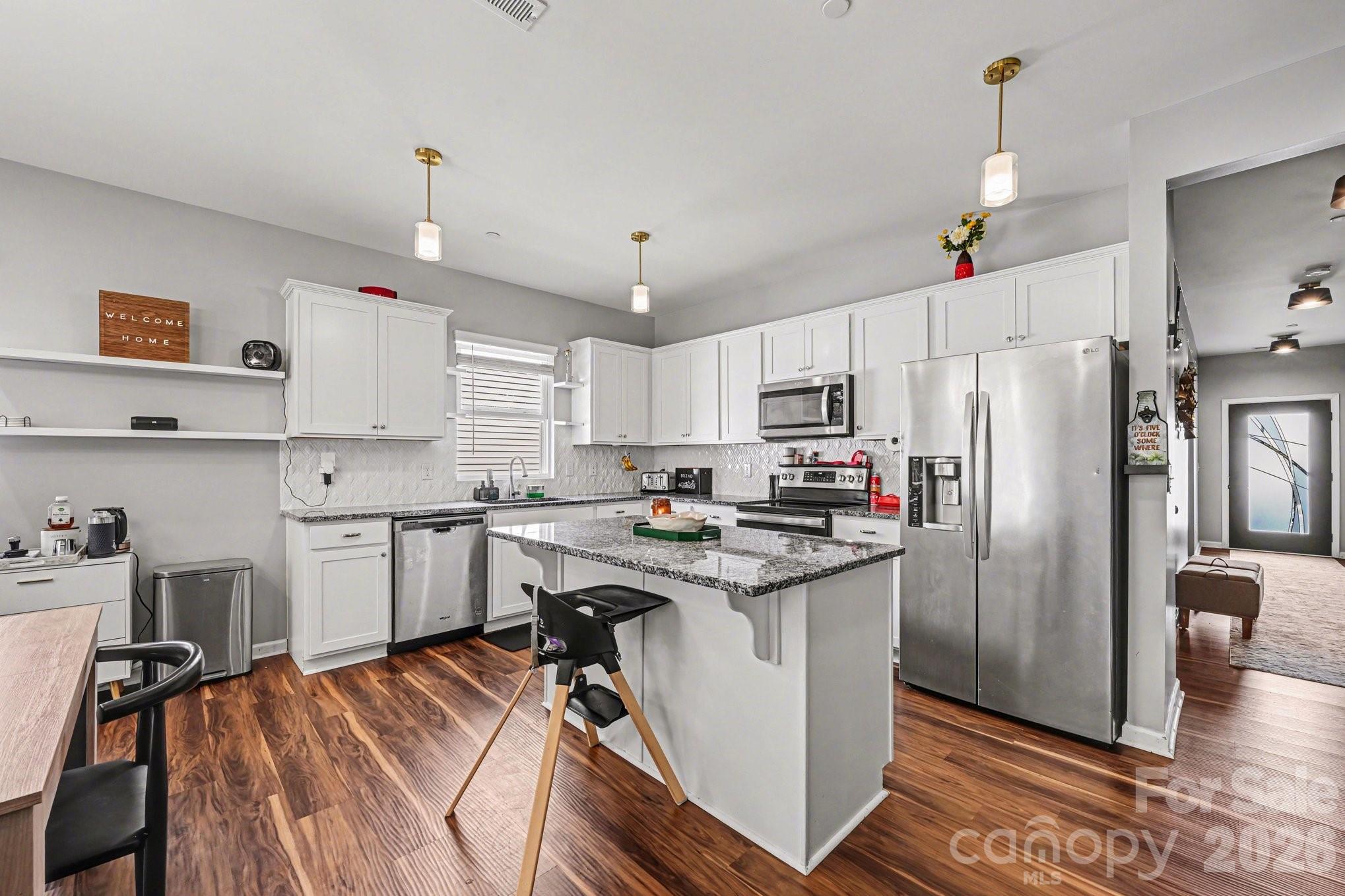 1235 Nesters Store Place Southwest Concord, NC 28027 - Photo 4 of 21 a kitchen with stainless steel appliances granite countertop a refrigerator a sink dishwasher a stove and white countertops with wooden floor