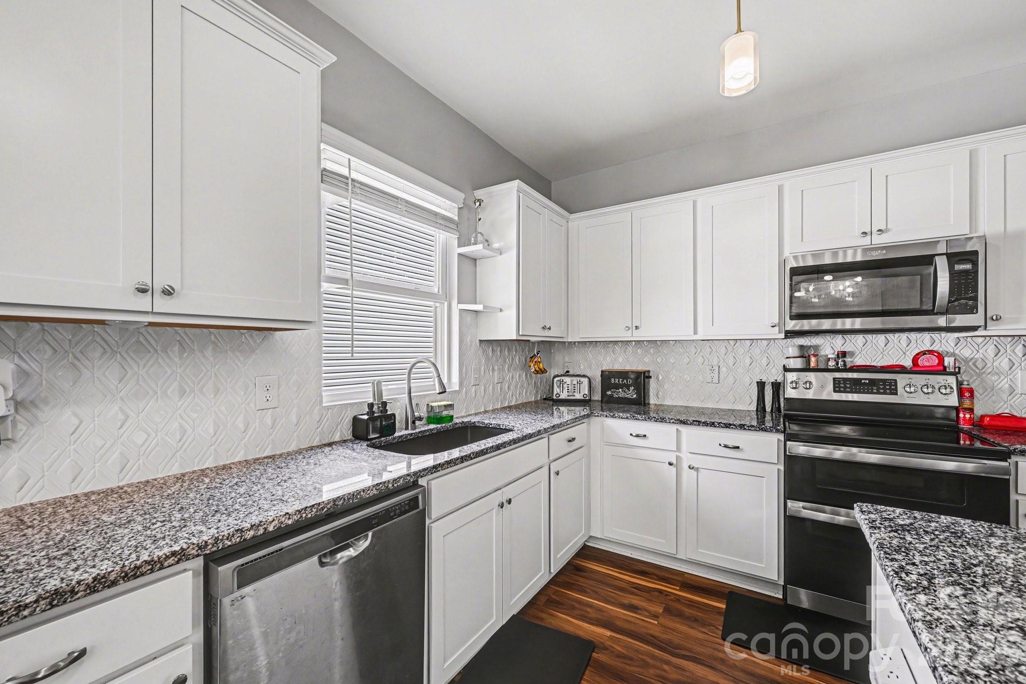 1235 Nesters Store Place Southwest Concord, NC 28027 - Photo 6 of 21 a kitchen with granite countertop a sink a stove and cabinets