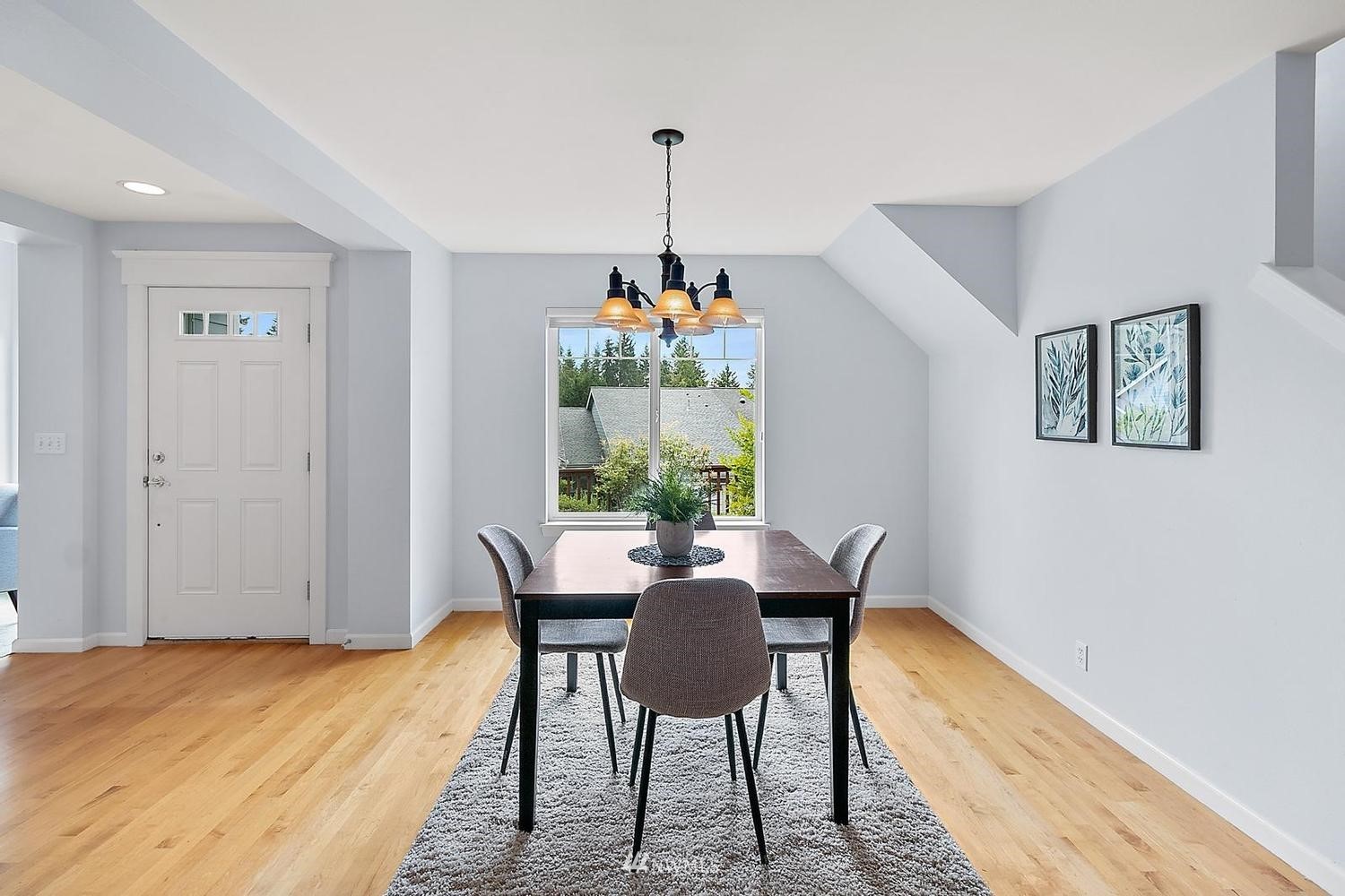 91 East Soderberg Road, Unit E14 Allyn, WA 98524 - Photo 9 of 40 a dining room with furniture a chandelier and wooden floor