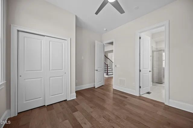 a view of a white house next to a yard with big trees