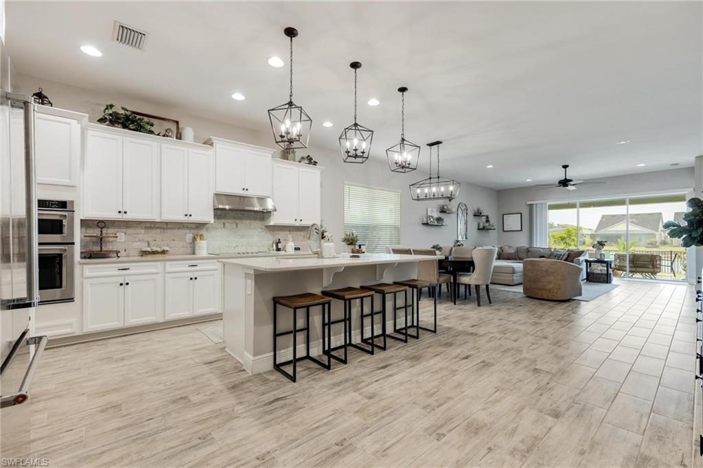 3621 Pilot Circle Naples, FL 34120 - Photo 20 of 46 a large white kitchen with lots of counter space a sink stainless steel appliances and cabinets