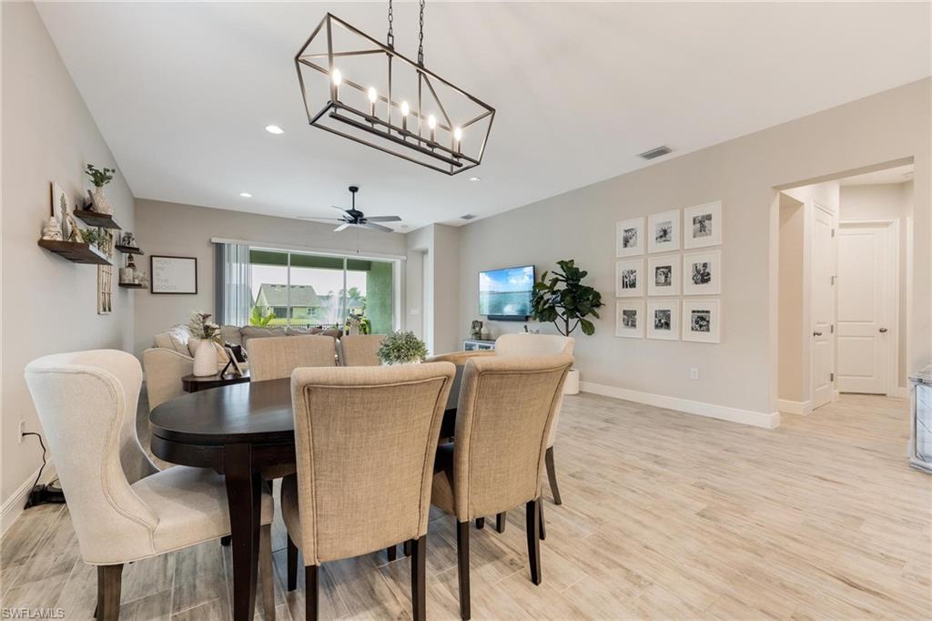 3621 Pilot Circle Naples, FL 34120 - Photo 23 of 46 a dining room with furniture a chandelier and wooden floor