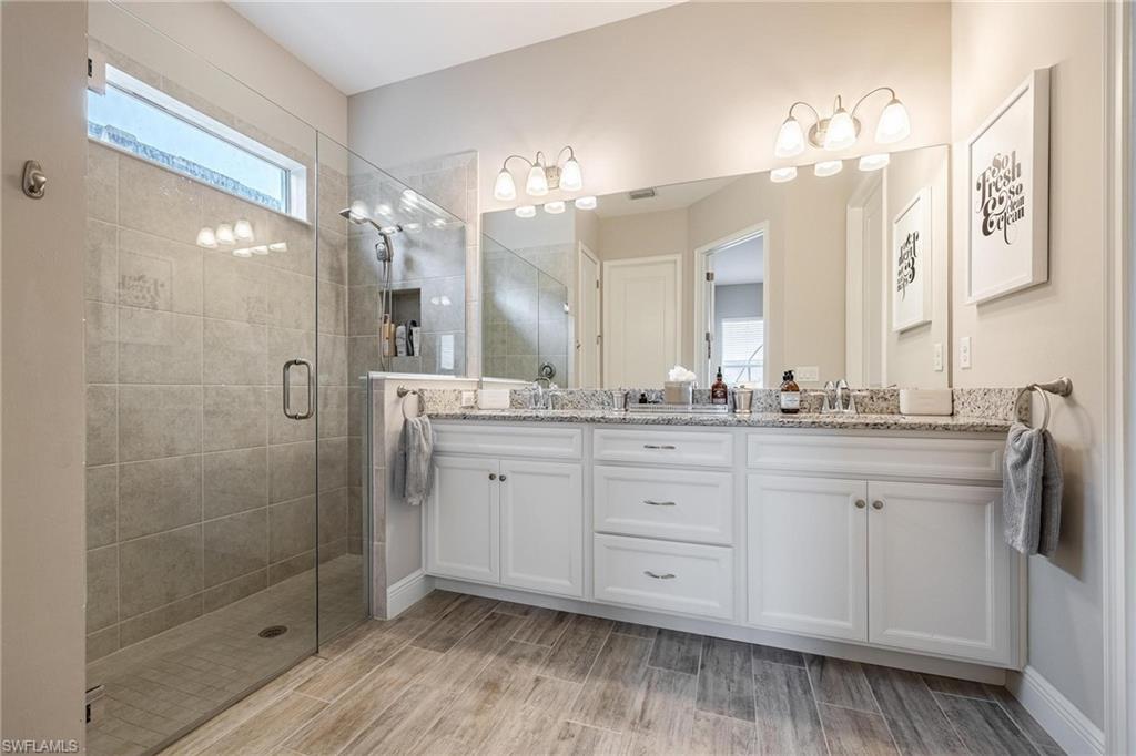 3621 Pilot Circle Naples, FL 34120 - Photo 27 of 46 a spacious bathroom with a granite countertop sink a mirror and shower