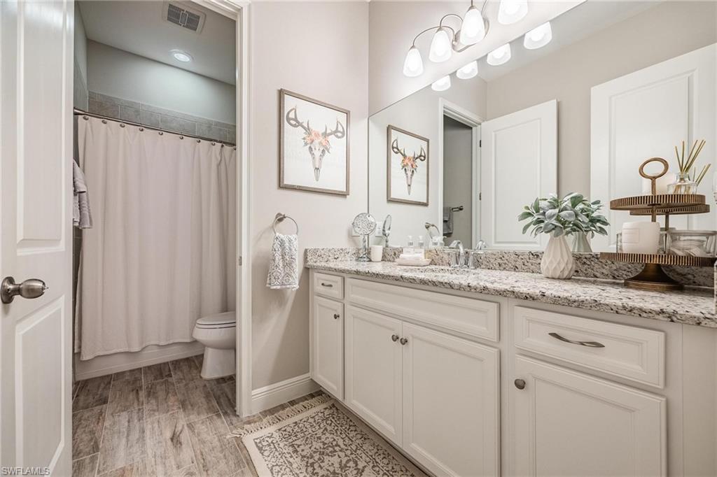 3621 Pilot Circle Naples, FL 34120 - Photo 30 of 46 a bathroom with a granite countertop sink a mirror and a shower