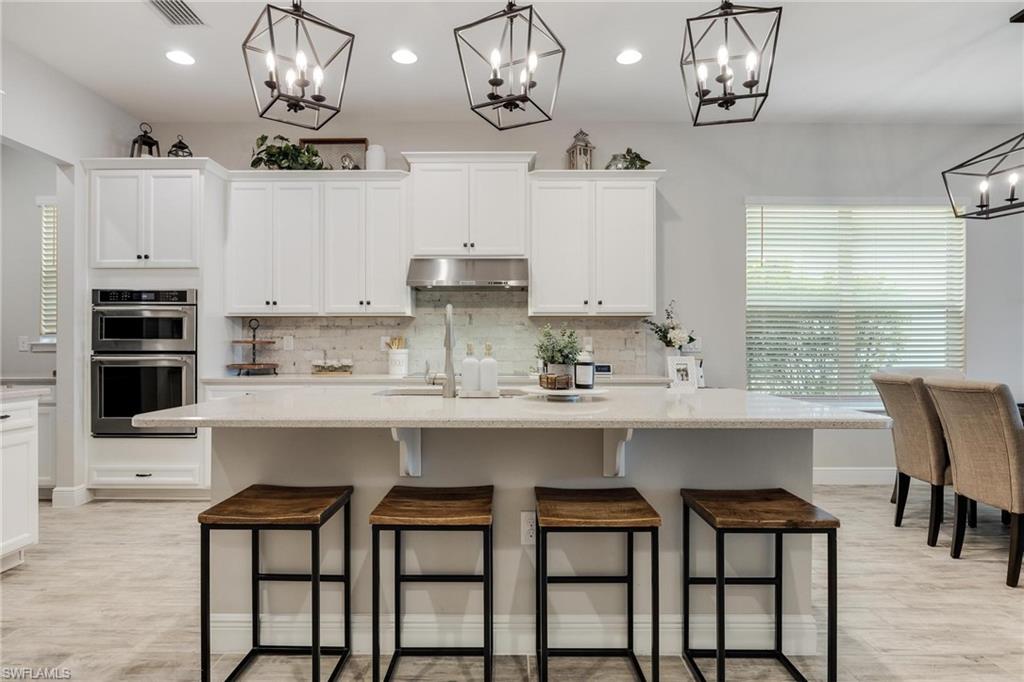 3621 Pilot Circle Naples, FL 34120 - Photo 7 of 46 a kitchen with cabinets and chairs in it