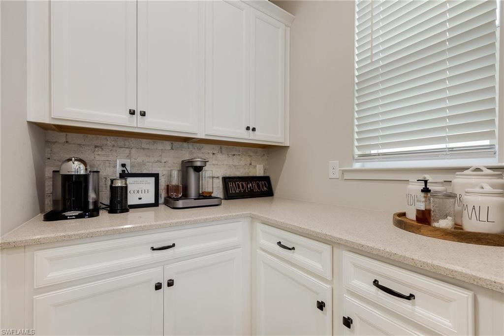 3621 Pilot Circle Naples, FL 34120 - Photo 9 of 46 a kitchen with white cabinets and a sink