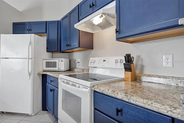 a kitchen with a sink a refrigerator and cabinets