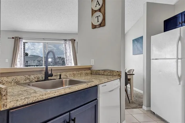 a kitchen with a sink refrigerator and window