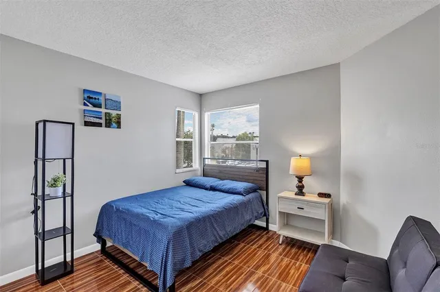 a bedroom with a bed and wooden floor