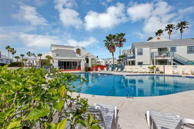 a view of a swimming pool with a patio and a yard