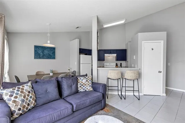 a living room with furniture and kitchen view