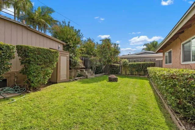 a view of a backyard with table and chairs potted plants and wooden fence