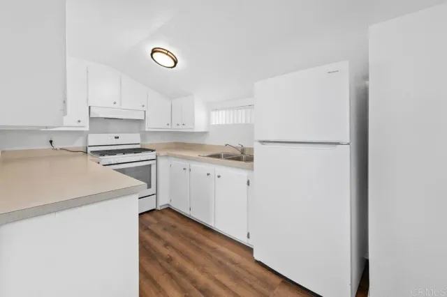 a kitchen with cabinets appliances and a window