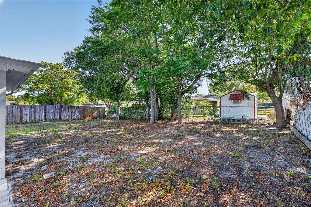 10914 Leeds Road Port Richey, FL 34668 - Photo 21 of 24 a view of a house with a yard and large tree
