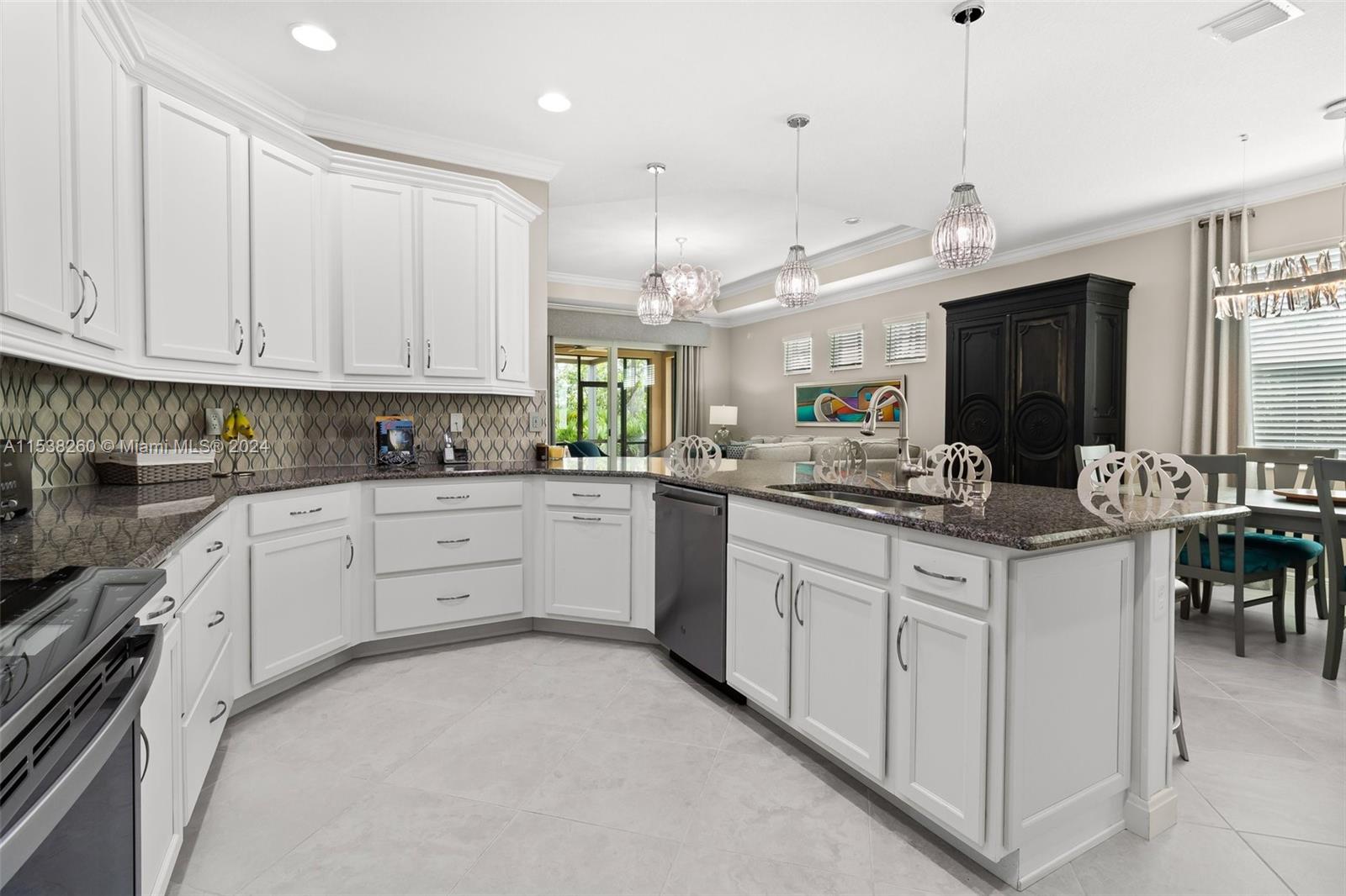 a kitchen with granite countertop a sink stainless steel appliances and white cabinets