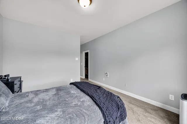 a bedroom with a bed and a wall painting