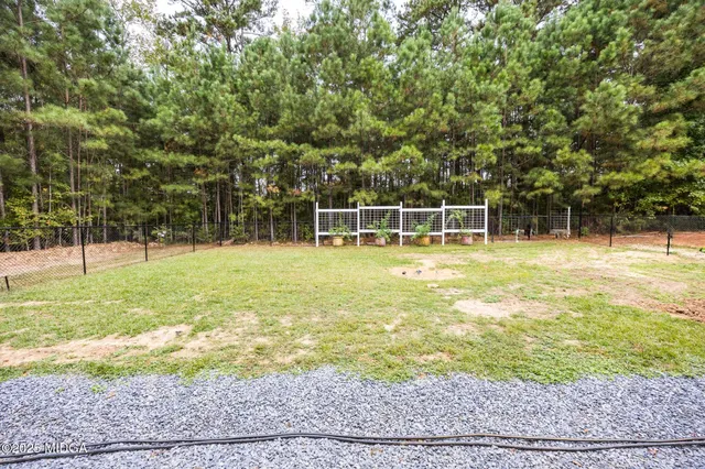 a view of a house with garden and a trees