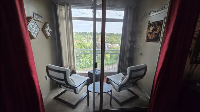 a view of a livingroom with lounge chair and a large window