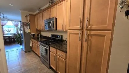 a kitchen with stainless steel appliances granite countertop a refrigerator and a stove