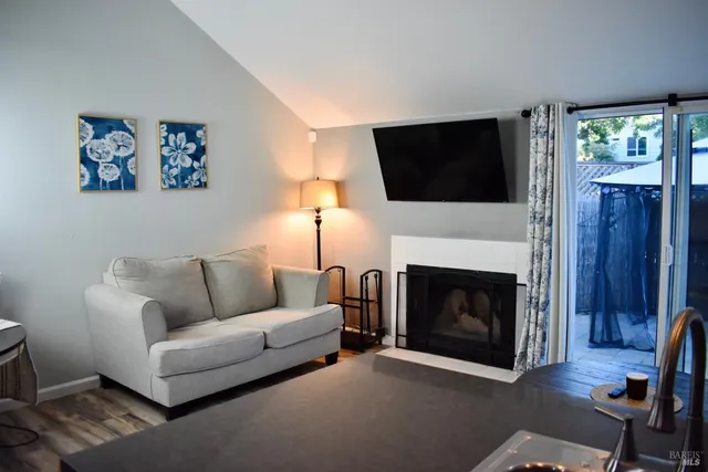 a living room with furniture a flat screen tv and a fireplace