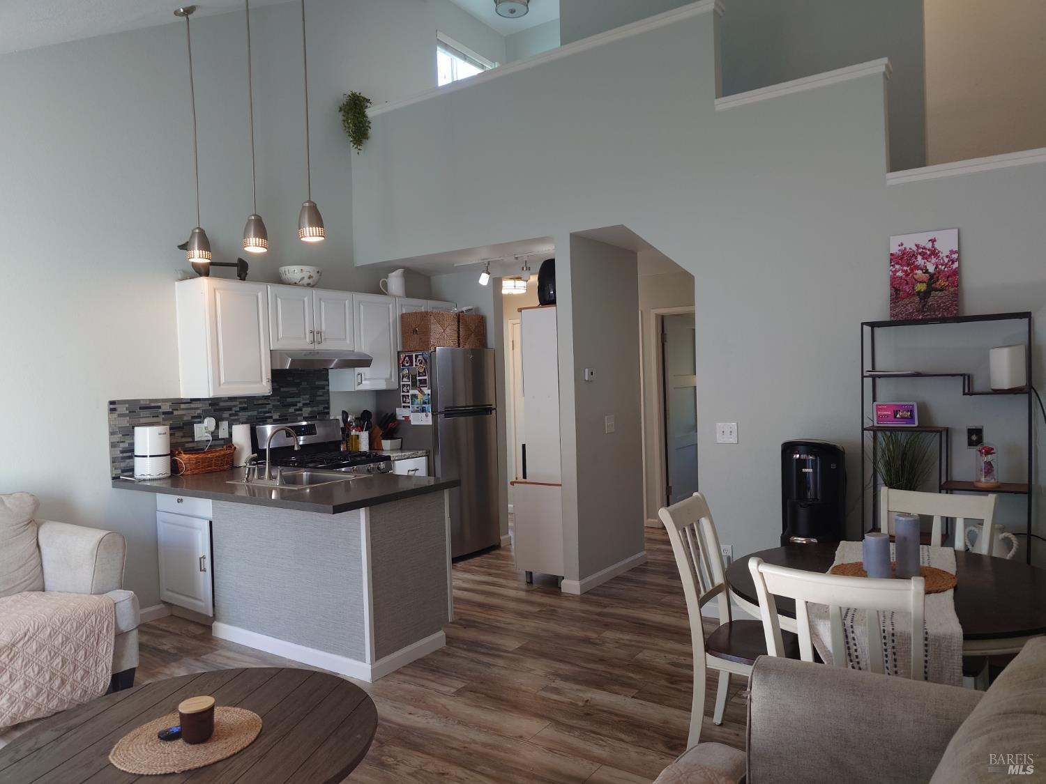 172 Courtyards East Windsor, CA 95492 - Photo 6 of 15 a kitchen with stainless steel appliances kitchen island granite countertop a refrigerator a stove top oven a dining table and chairs with wooden floor