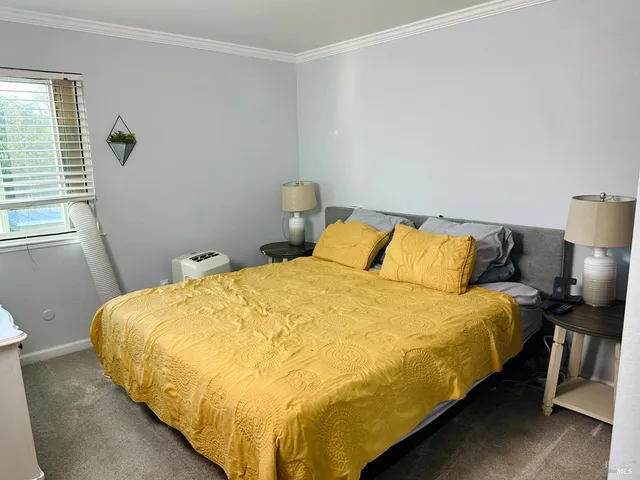 a large bed sitting in a bedroom next to a window and wooden floor
