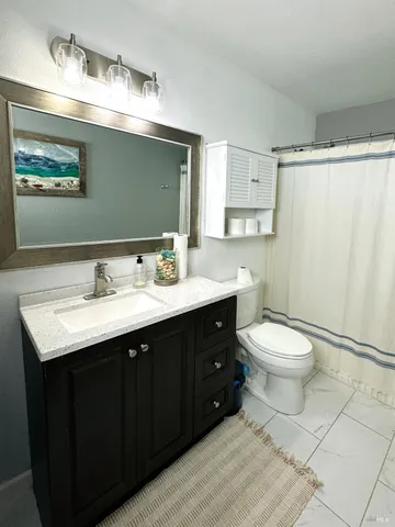 a bathroom with a toilet sink and mirror