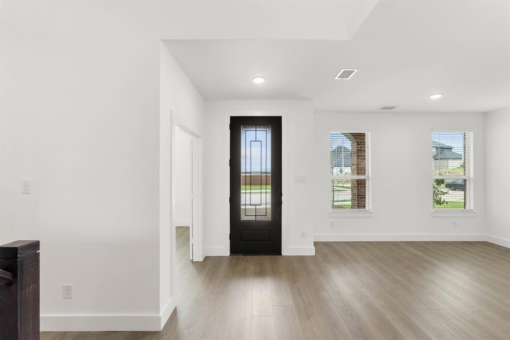 413 Tower Street DeSoto, TX 75115 - Photo 3 of 30 a view of an empty room with wooden floor and windows