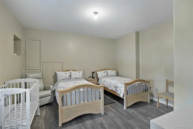 a bedroom with two beds and wooden floor