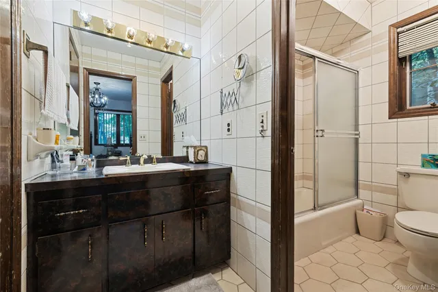 a bathroom with a sink a toilet a mirror and shower