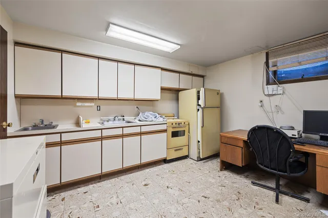 a kitchen with refrigerator a stove a sink and cabinets