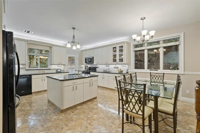 a kitchen with kitchen island granite countertop a counter space dining table and stainless steel appliances