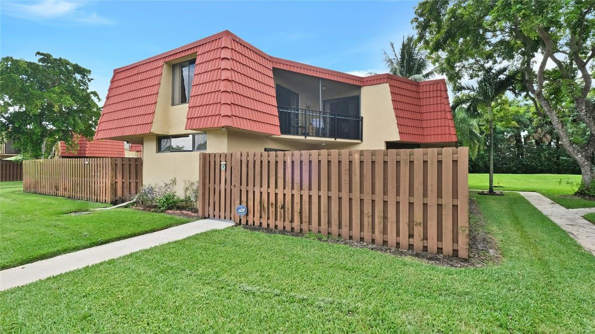 8146 Thames Boulevard, Unit A Boca Raton, FL 33433 - Photo 1 of 18 a front view of a house with yard and green space