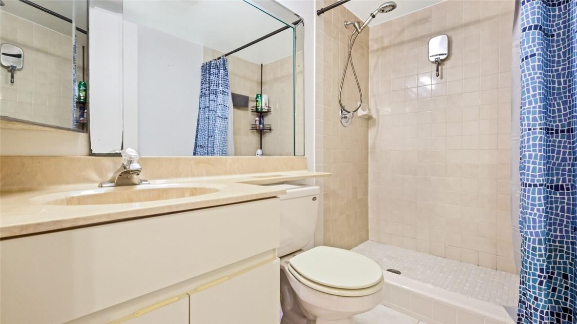 8146 Thames Boulevard, Unit A Boca Raton, FL 33433 - Photo 11 of 18 a bathroom with a granite countertop sink toilet and shower