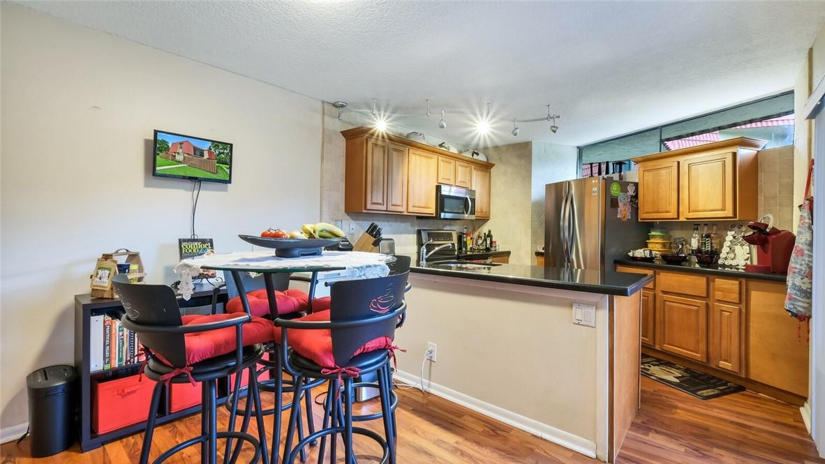 8146 Thames Boulevard, Unit A Boca Raton, FL 33433 - Photo 5 of 18 a kitchen with stainless steel appliances kitchen island granite countertop a dining table chairs and a refrigerator