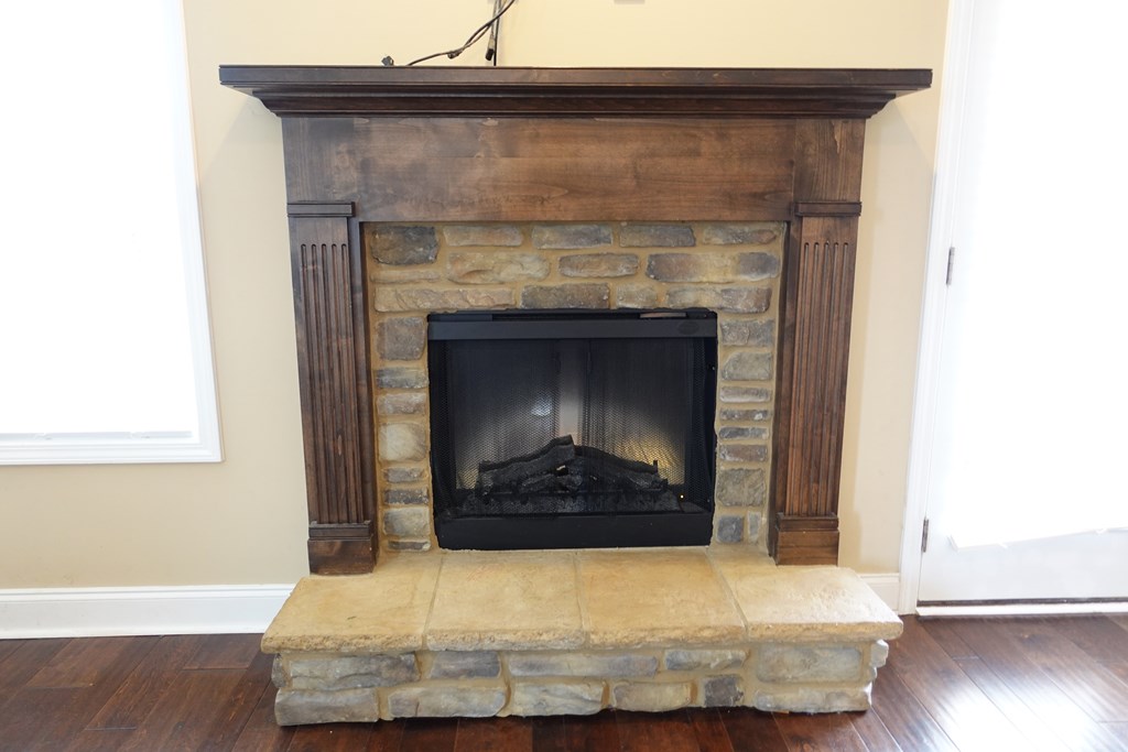 9981 Coppice Court Midland, GA 31820 - Photo 11 of 33 a living room with a fireplace and a wooden floor