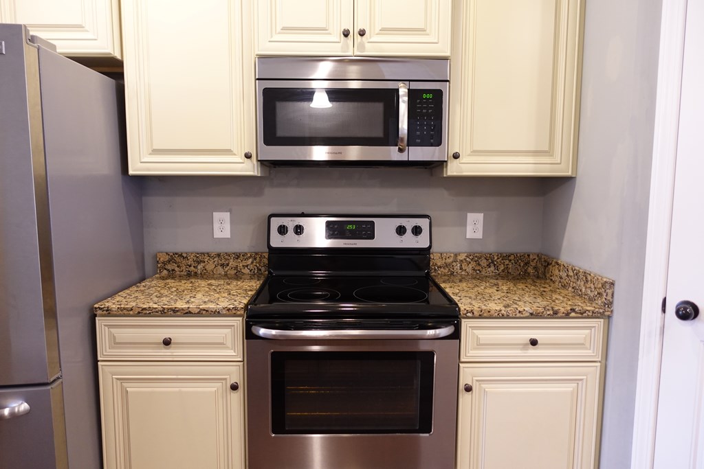 9981 Coppice Court Midland, GA 31820 - Photo 4 of 33 a kitchen with stainless steel appliances granite countertop white cabinets stove top oven and sink