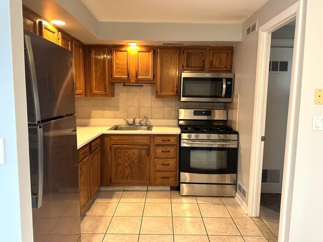 a kitchen with granite countertop a refrigerator and a stove