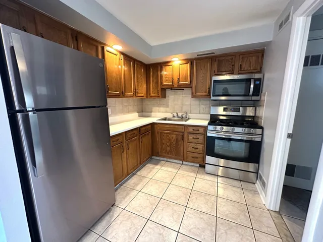 a kitchen with stainless steel appliances a refrigerator sink and cabinets