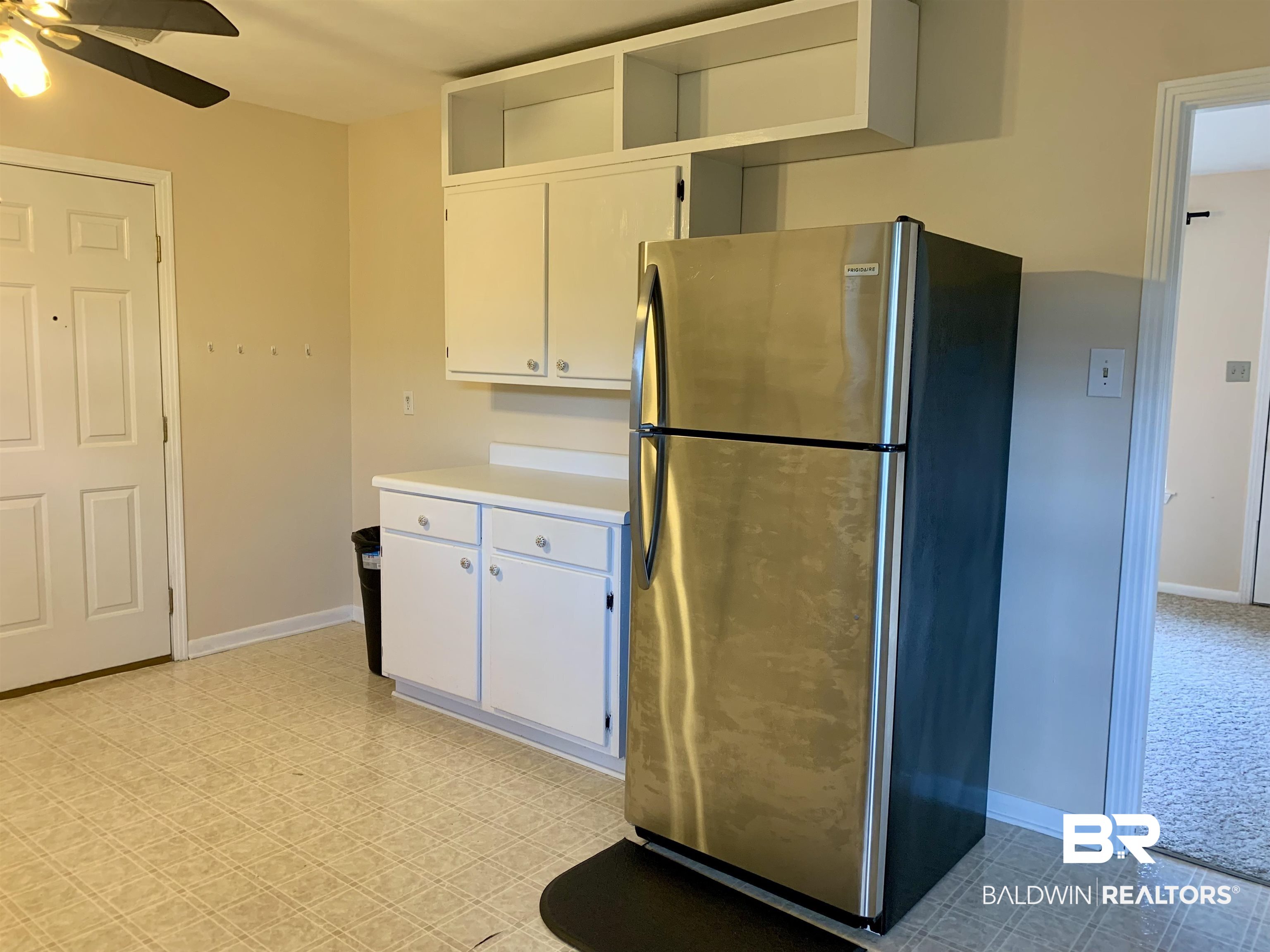2710 West Road Mobile, AL 36693 - Photo 4 of 10 Kitchen with white cabinetry, ceiling fan, stainless steel fridge, and light colored carpet