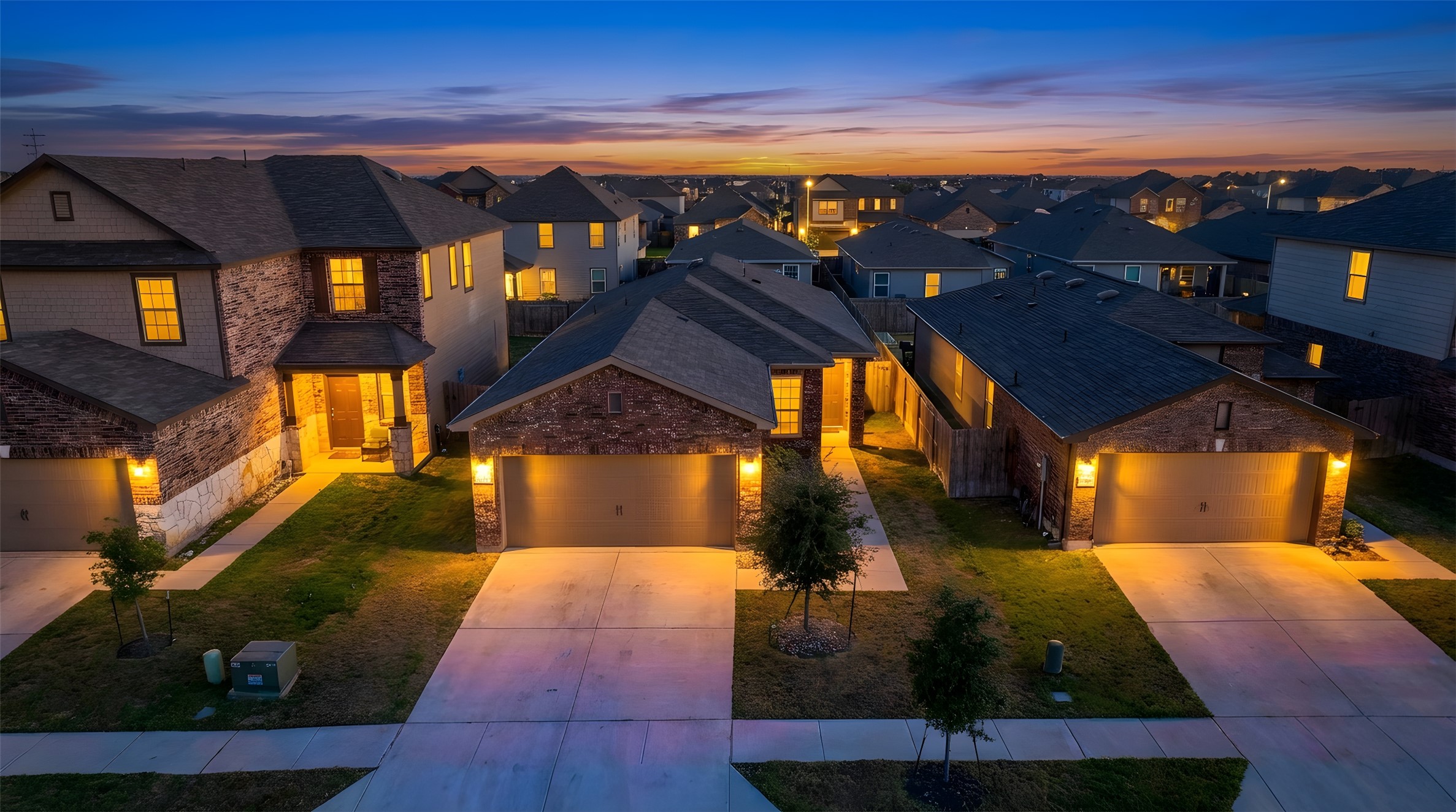 View of front of home featuring a front lawn, stone siding, a residential view, and driveway