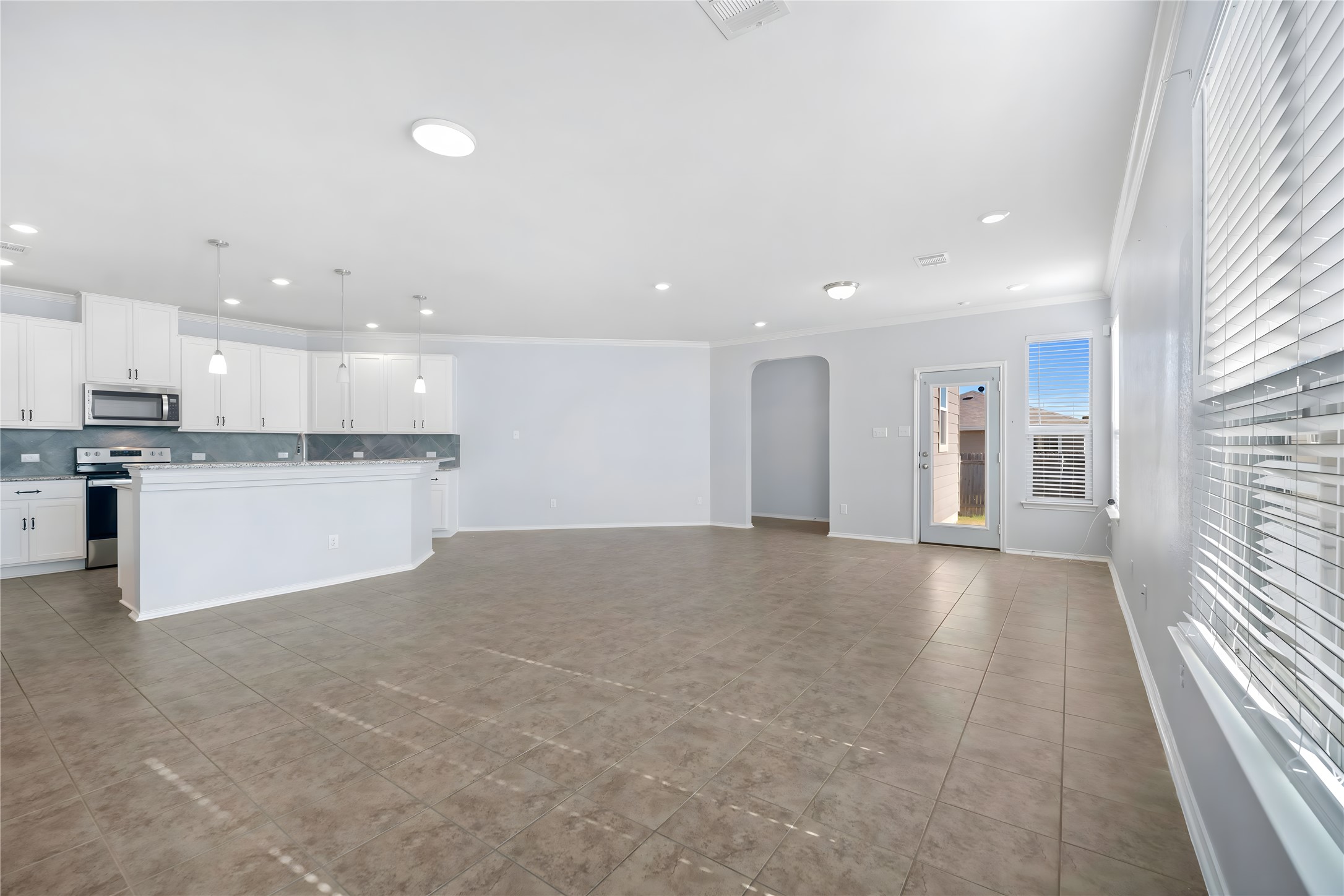 13917 Inaugural Street Manor, TX 78653 - Photo 5 of 39 Unfurnished living room featuring arched walkways, recessed lighting, and ornamental molding