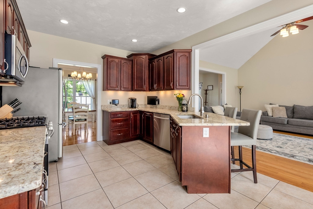 63 Vista Circle Holden, MA 01520 - Photo 11 of 36 a kitchen with granite countertop a refrigerator stove top oven and cabinets