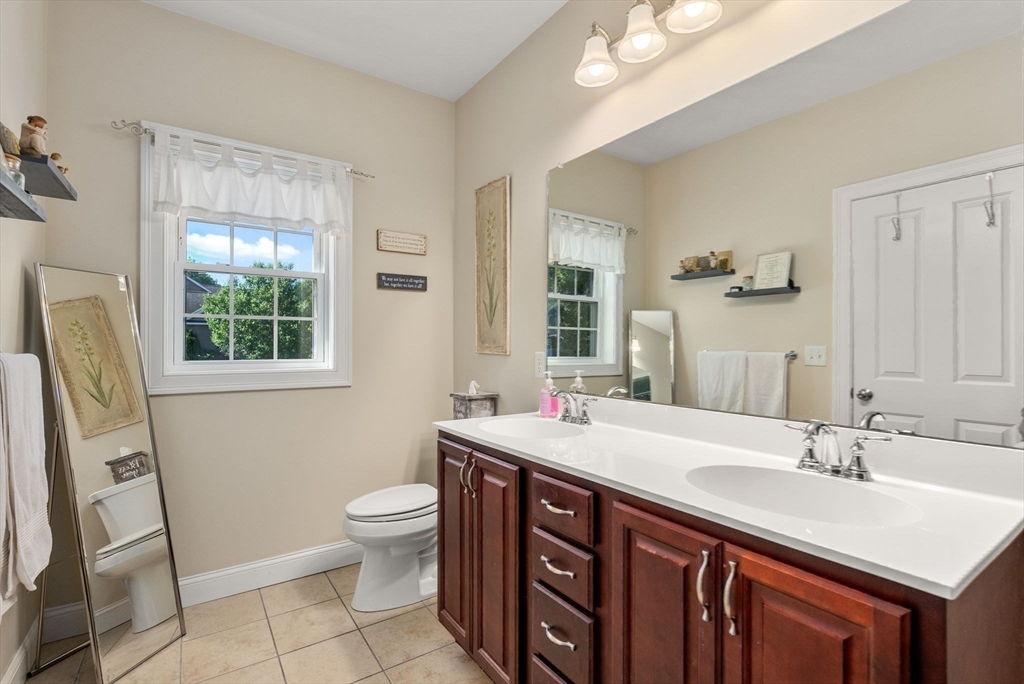63 Vista Circle Holden, MA 01520 - Photo 21 of 36 a bathroom with a sink a toilet a mirror and a window