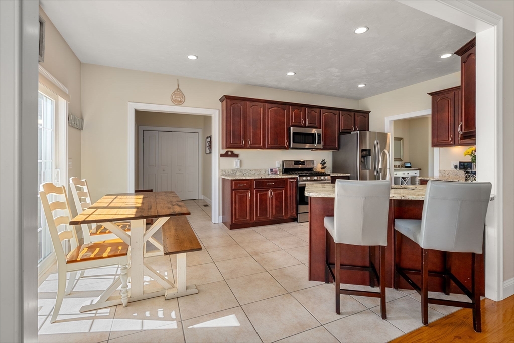 63 Vista Circle Holden, MA 01520 - Photo 9 of 36 a kitchen with stainless steel appliances granite countertop a stove a sink a microwave a dining table and chairs