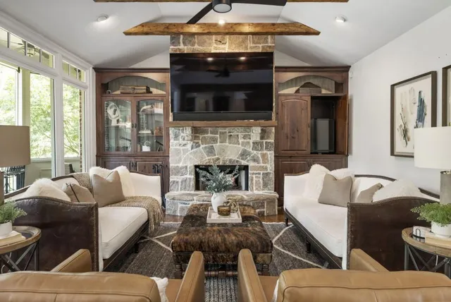 a living room with furniture a flat screen tv and a fireplace