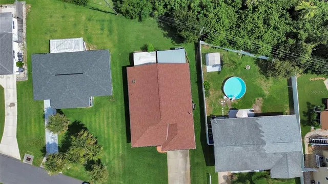 an aerial view of a house with a yard and seating space