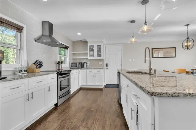 a kitchen with granite countertop a sink a counter space appliances and cabinets