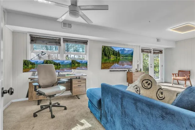 a view of a workspace with furniture and a window